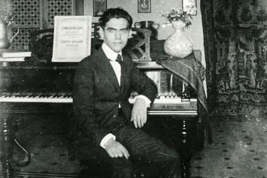 Federico García Lorca sitting in front of the piano